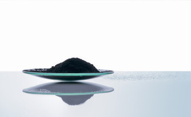 Carbon Charcoal Powder in Chemical Watch Glass. Close up chemical ingredient on white laboratory...
