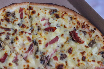 Close up of Pizza complete with cheese, salami, pineapple, mushrooms and condiments, weekend dinner, family.