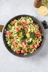 Salad with bulgur, tomatoes, cucumbers and parsley. Tabouleh dish. Oriental cuisine. 