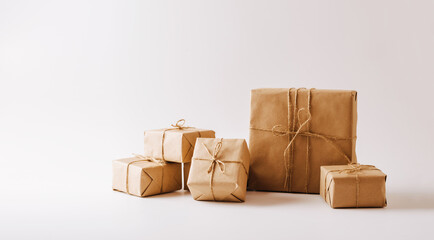 Gifts in eco-friendly paper packaging on a white background. Copy space concept minimalism - obrazy, fototapety, plakaty