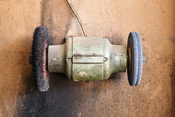 Worn old electric bench grinding machine or grinder mounted on the wall