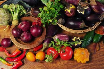 Eggplants, red onions and other vegetables on a wooden table. 