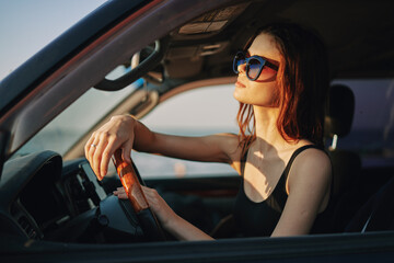 Naklejka na ściany i meble pretty woman in sunglasses driving a car trip