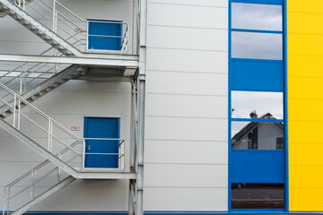 Entrance of a warehouse with reflection of a family house