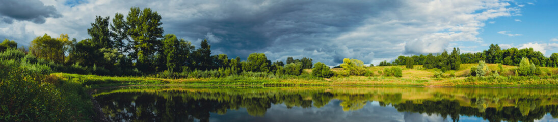 Fototapeta na wymiar Dark stormy clouds over the lake