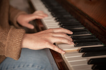Fototapeta premium Close-up of female hands playing the piano.
