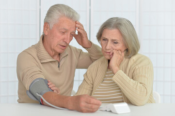 senior couple measuring blood pressure together