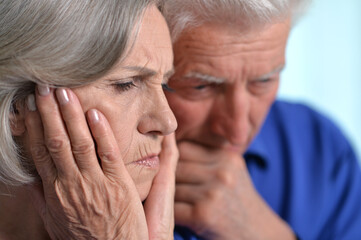 Portrait of sad senior couple posing at home