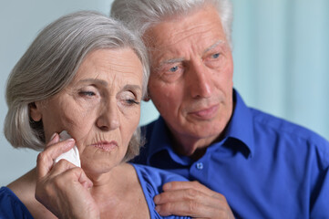 Portrait of sad senior couple posing at home