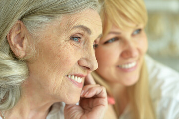 Portrait of senior woman with daughter at home