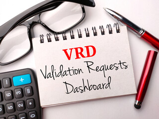 Glasses,calculator,pen and notebook with text VRD validation requests dashboard on a white...