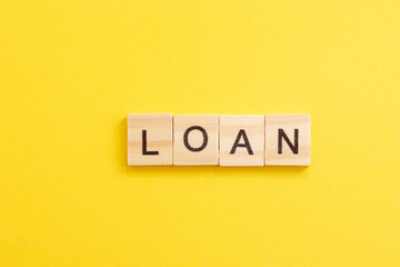 Wooden word LOAN. Concept of buying an apartment or house in debt