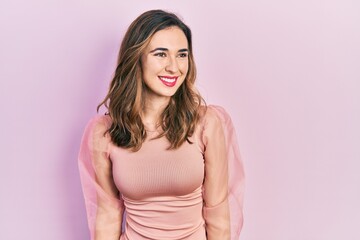 Fototapeta premium Young hispanic girl wearing casual clothes looking away to side with smile on face, natural expression. laughing confident.