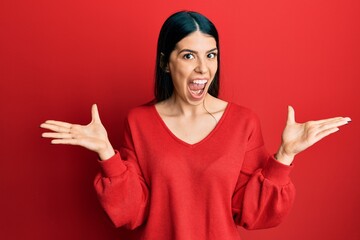 Young hispanic woman wearing casual clothes celebrating victory with happy smile and winner expression with raised hands