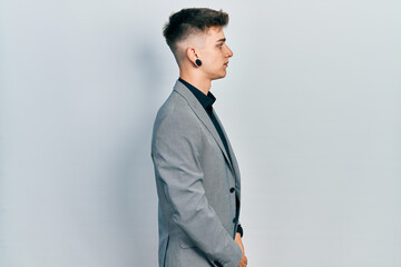 Young caucasian boy with ears dilation wearing business jacket looking to side, relax profile pose...