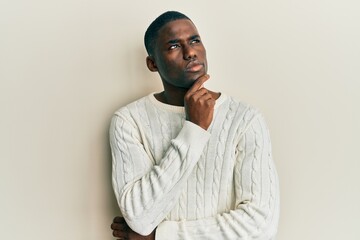 Obraz premium Young african american man wearing casual clothes with hand on chin thinking about question, pensive expression. smiling with thoughtful face. doubt concept.