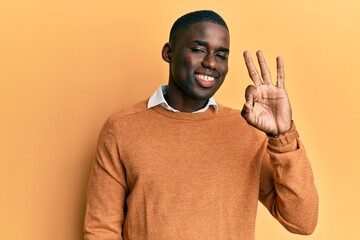 Young african american man wearing casual clothes smiling positive doing ok sign with hand and fingers. successful expression.