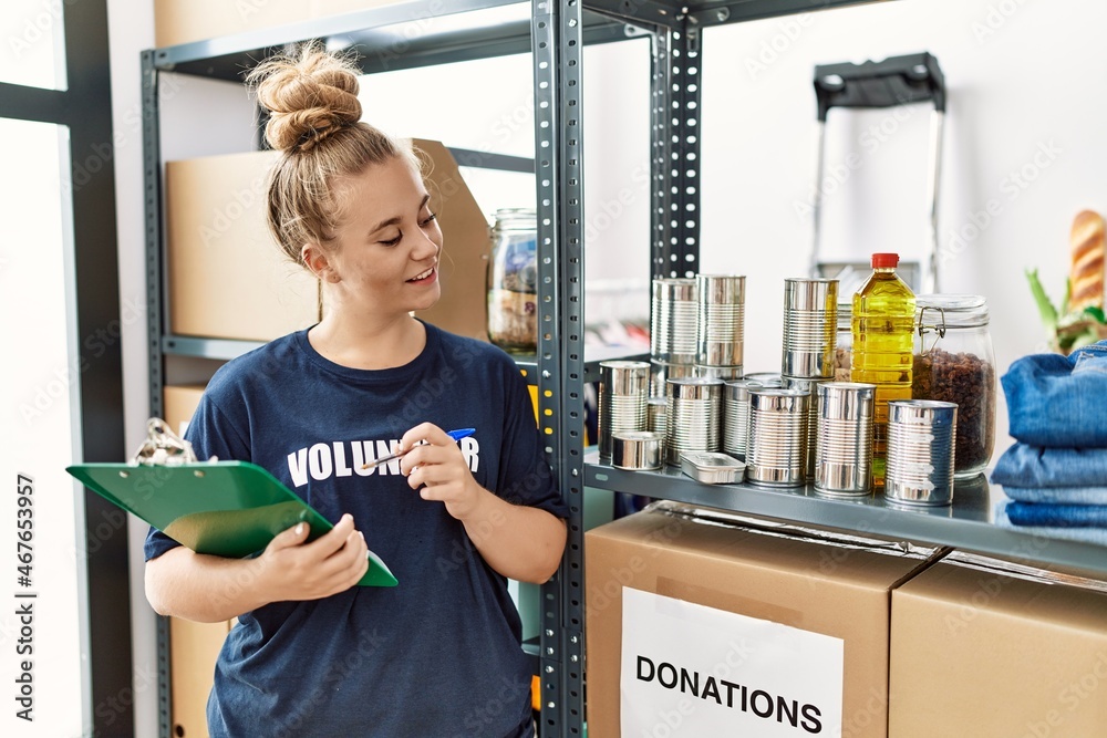 Poster Young blonde girl wearing volunteer uniform working at charity center