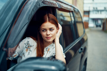 Fototapeta na wymiar cheerful woman driving a car looks out of the window