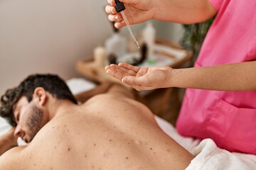 Man reciving back massage with oil at beauty center.