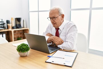 Senior man working at the office using computer laptop looking sleepy and tired, exhausted for fatigue and hangover, lazy eyes in the morning.
