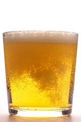 light beer in a glass on a white background with bubbles and foam