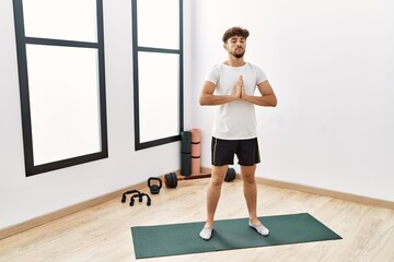 Obraz premium Young arab man training yoga at sport center