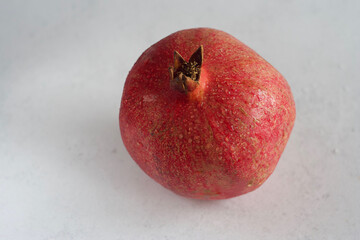 The pomegranate lies on a gray concrete table.