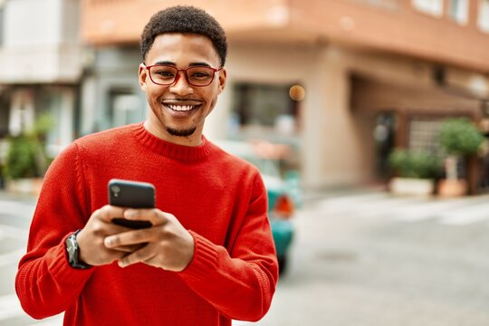 Handsome african american man outdoors using smartphone typing a message