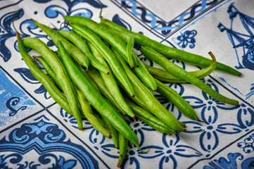 Green beans on blue and white background. Top view. Close up.