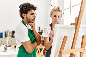 Paint teacher man teaching to student woman at art studio.