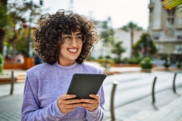 Young middle east woman smiling confident using touchpad at street