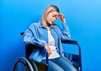 Beautiful caucasian woman sitting on wheelchair tired rubbing nose and eyes feeling fatigue and headache. stress and frustration concept.