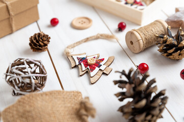 Wooden Christmas tree ornament with twine and button decoration surrounded by rustic Christmas decorations