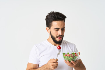 a man in a white t-shirt in a plate with salad a snack healthy food