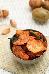 Homemade Kering Kentang Balado or Spicy Sweet Crispy Potato with Caramelized Spice. Using Lime Leaf for Aromatic Spice. Served on Grey Bowl, White Background