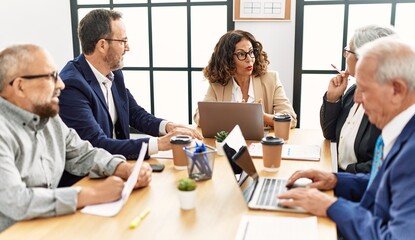 Group of middle age business workers smiling happy working at the office