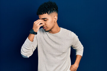 Young african american man wearing casual clothes tired rubbing nose and eyes feeling fatigue and headache. stress and frustration concept.