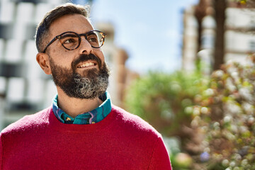 Young hispanic executive man smiling happy standing at the city.