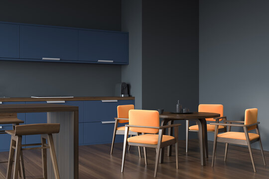 Grey and blue kitchen with orange chairs. Corner view.