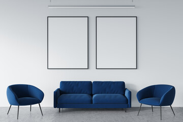 Blue office seating area with two empty canvases on white wall