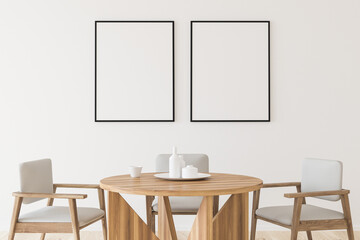 Two empty canvases on wall in white dining room