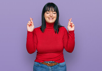 Young hispanic woman wearing casual clothes gesturing finger crossed smiling with hope and eyes closed. luck and superstitious concept.