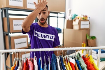 African american man wearing volunteer t shirt at donations stand surprised with hand on head for...