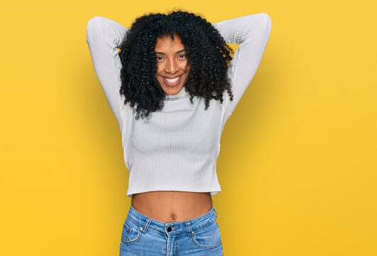Young african american girl wearing casual clothes relaxing and stretching, arms and hands behind head and neck smiling happy