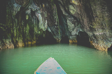 Kayaking through underground cave system with bats and stallegtites. Dark low light photography 