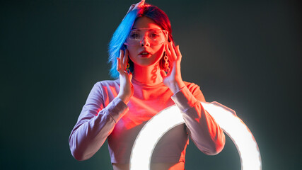 Cyberpunk fashion. Neon light portrait. Sci-fi futurism. Attractive futuristic woman model with LED...