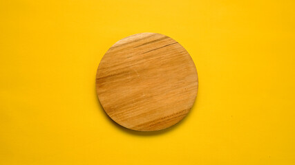 round wooden cutting Board side angle isolated on yellow background