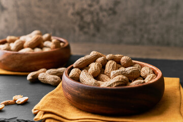 Image of bunch of peanuts in a bowl on a slate surface