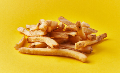  Bunch of french fried potatoes on a yellow background